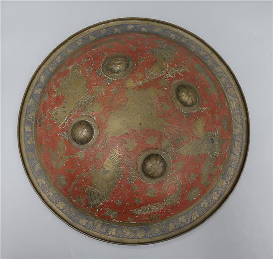 A Benares engraved brass and red enamel shield diameter 36cm